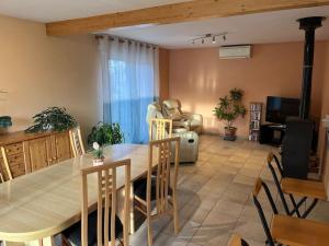 een woonkamer met een tafel en stoelen en een bank bij Maison familiale avec terrain in Orchamps-Vennes