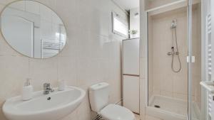 ein Badezimmer mit einem Waschbecken, einem WC und einem Spiegel in der Unterkunft Chic apart with parking and balcony near Paris in Aubervilliers