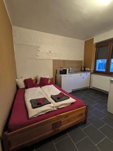 1 dormitorio con 1 cama grande con sábanas rojas en Penzion U Ježů - Ubytování en Pasohlávky