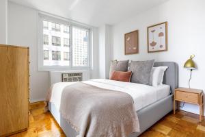 Ένα ή περισσότερα κρεβάτια σε δωμάτιο στο Midtown 2BR w Gym Doorman nr Central Park NYC-507