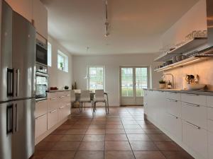 Viken的住宿－Gamla Viken, 150 qm, 3 bedroom, 6 beds，厨房配有白色橱柜和瓷砖地板。