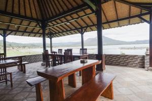 een paviljoen met tafels en stoelen en uitzicht op het water bij Baruna Lakeside View in Kubupenlokan