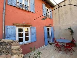 a patio with a table and chairs in front of a building at Maison familiale centre Avignon in Avignon