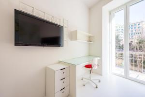 een wit kantoor met een bureau en een tv aan de muur bij Morghen Red Passion and Pop Art in Napels