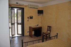 een slaapkamer met een tafel, een stoel en een bureau bij Agriturismo Sechi in Campanedda