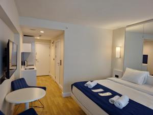 een hotelkamer met een bed, een tafel en een stoel bij Twin Towers Orbi City Batumi in Batoemi