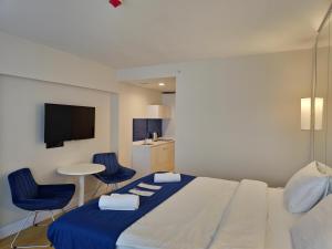 a bedroom with a bed and two chairs and a table at Twin Towers Orbi City Batumi in Batumi