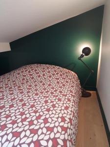 a bedroom with a bed and a lamp in a room at Le nichoir aux oiseaux avec Parking in Paris