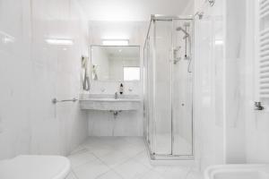 a white bathroom with a shower and a sink at Hotel Sogno del Benaco in Limone sul Garda +25 photos