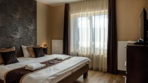 a bedroom with a bed and a large window at Family Apartman in Eplény