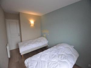 a bedroom with two white beds in a room at Victory25 in Le Touquet-Paris-Plage