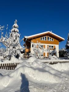 a person walking in the snow in front of a house at Ferienwohnung Lory mit Schlossblick in Halblech