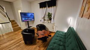 a living room with a couch and a flat screen tv at Haus (1. Etage+DG) mit Garten in Passendorf