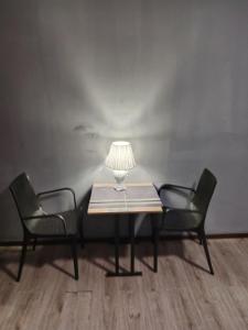 a table with two chairs and a lamp on it at A cozy bedsit! in Tashkent