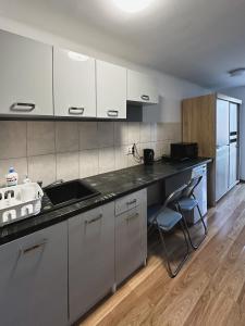 a kitchen with white cabinets and a counter top at Kwadrat B&B Spiechowicza in Rzeszów