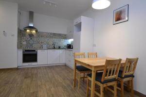 eine Küche mit einem Holztisch und Stühlen in der Unterkunft Apartament SZMARAGDOWY z garażem Centrum Gliwic-Klimatyzacja in Gliwice