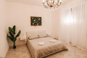 um quarto branco com uma cama e um lustre em Renaissance Apartment em Roma