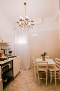 uma cozinha com mesa e cadeiras e um candelabro em Renaissance Apartment em Roma