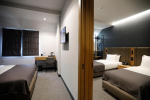 a hotel room with two beds and a desk at Graf Hotel in Tbilisi City