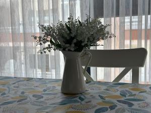 a vase of flowers sitting on a table with a chair at Cozy 2-Bedroom Apartment, Cleopatra Beach, Alanya in Alanya