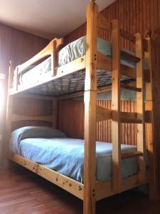 two bunk beds in a room with wooden walls at L'abri de Pila in Gressan