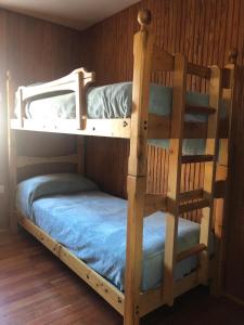 two bunk beds in a room with wooden walls at L'abri de Pila in Gressan