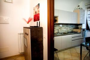 una pequeña cocina con nevera y fregadero en Casa Fedele, en LʼAquila