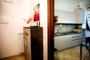 a small kitchen with a refrigerator and a sink at Casa Fedele in LʼAquila