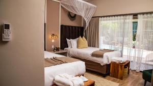 a hotel room with two beds and a window at The Telescope Boutique Lodge in Victoria Falls