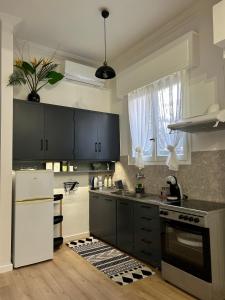 una cucina con armadi neri e frigorifero bianco di Seaside Casa a Nafpaktos