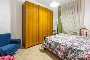 a bedroom with a bed and a wooden cabinet at Monserrato Cozy Apartment near the Policlinico! in Monserrato