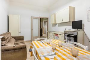 ein Wohnzimmer mit einem Tisch und einem Sofa in der Unterkunft Monserrato Cozy Apartment near the Policlinico! in Monserrato
