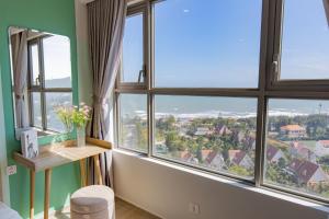 a room with large windows with a view at Phạm Hiếu's Homestay - The Song Apartment in Vung Tau