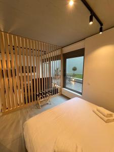 a bedroom with a bed and a view of the ocean at Brand New Luxurious Apartment in Kerameikos-Gazi (Athens Historical Center), Metro Station 'Kerameikos' in Athens