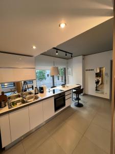 a large kitchen with white cabinets and a table at Brand New Luxurious Apartment in Kerameikos-Gazi (Athens Historical Center), Metro Station 'Kerameikos' in Athens