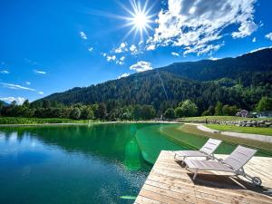 une chaise assise sur un quai à côté d'un lac dans l'établissement Stella Delle Alpi by Holiday World, à Pinzolo