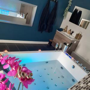 ein Badezimmer mit einer Badewanne mit rosa Blumen in der Unterkunft escapade romantique 56 in Plouray