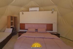 a bedroom with a bed in a tent at Bubble Sofia Luxury Rum Camp in Wadi Rum