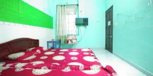 a bedroom with a bed with a red comforter at Hostel Loc Quyen in Da Nang