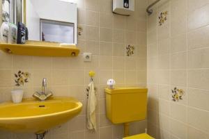 uma casa de banho com um lavatório amarelo e um WC. em Apartment mit Kamin-Sonnendurchflutet-Balkon em Winterberg