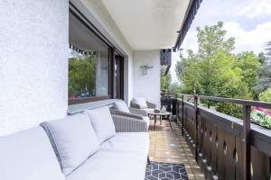 a balcony with white couches and a table at Apartment mit Kamin-Sonnendurchflutet-Balkon in Winterberg