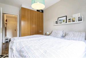 a bedroom with a white bed and a wooden cabinet at Apartment mit Kamin-Sonnendurchflutet-Balkon in Winterberg