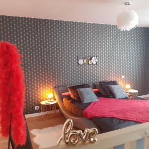 ein Schlafzimmer mit einem Bett mit einer roten Decke in der Unterkunft escapade romantique 56 in Plouray