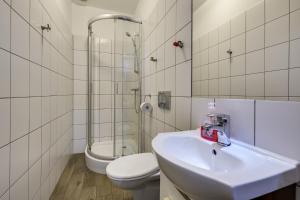een badkamer met een wastafel, een toilet en een douche bij Hostel Kattowitz in Katowice