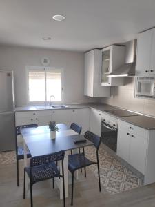 a kitchen with a table and chairs in it at Apartamento turístico "Mi casina" AT-CC-00782 in Casar de Cáceres