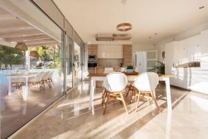 een keuken en eetkamer met een tafel en stoelen bij Villa Paraíso in Castelldefels