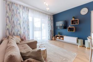 sala de estar con paredes azules y sofá en Blue Sea en Pogorzelica