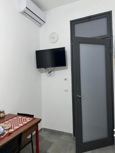 um quarto com uma porta e uma televisão na parede em Marrakech rooms 2 em Catânia