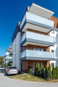 a building with a car parked in front of it at Blue Sea in Pogorzelica