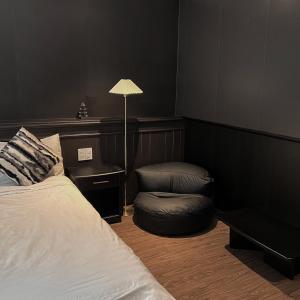une chambre avec un lit, une chaise et une lampe dans l'établissement The An House Dalat, à Đà Lạt